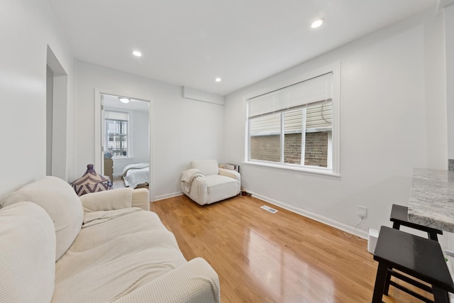 living area with baseboards, recessed lighting, light wood-style flooring, and visible vents