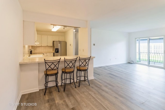 246 George St Unit C, Bensenville, IL 60106 - kitchen featuring a sink, stainless steel fridge with ice dispenser, a peninsula, decorative backsplash, and light wood-type flooring