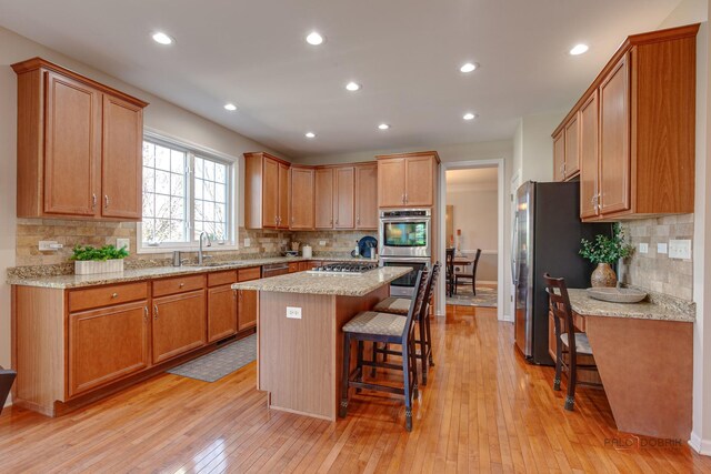 kitchen with a center island, stainless steel appliances, a kitchen bar, and decorative backsplash