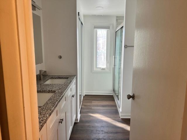 330 Oakwood St, Park Forest, IL 60466 - full bathroom featuring a shower stall, a sink, double vanity, baseboards, and wood finished floors