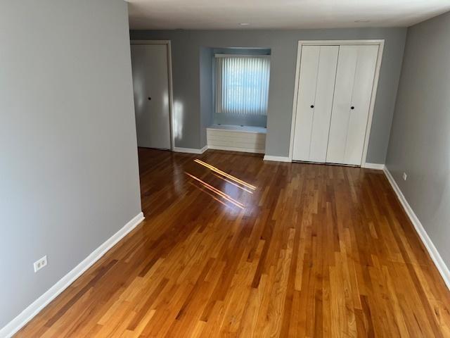 330 Oakwood St, Park Forest, IL 60466 - unfurnished bedroom featuring baseboards and wood finished floors
