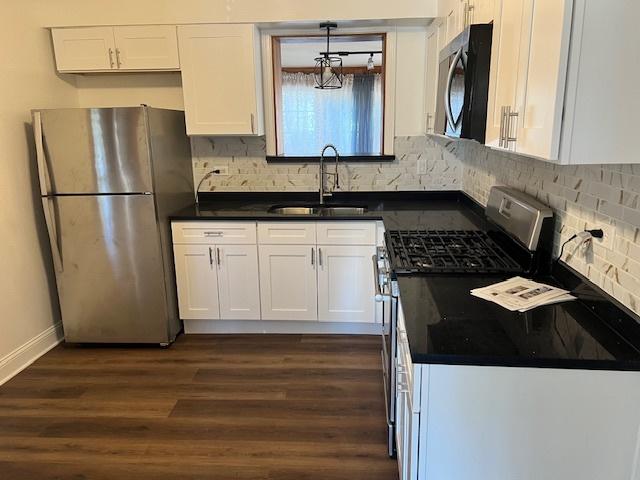 330 Oakwood St, Park Forest, IL 60466 - kitchen featuring dark countertops, white cabinetry, stainless steel appliances, and a sink