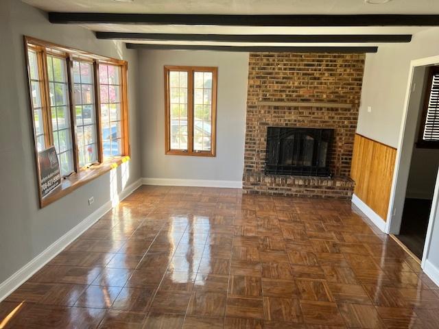 330 Oakwood St, Park Forest, IL 60466 - unfurnished living room with beam ceiling, baseboards, and a brick fireplace