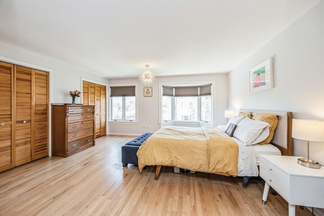 bedroom featuring multiple closets, light wood-style flooring, and baseboards