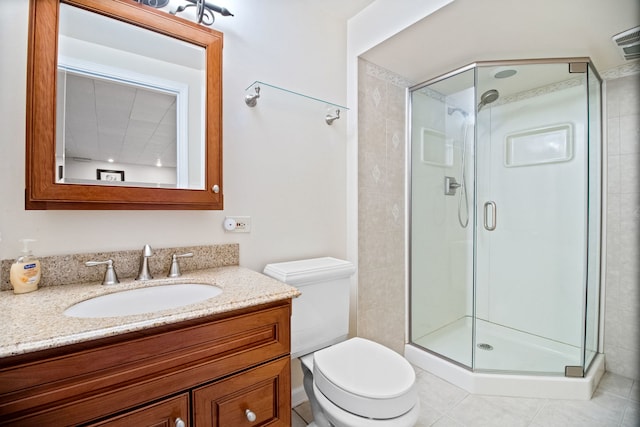 full bath featuring a stall shower, toilet, vanity, and tile patterned flooring