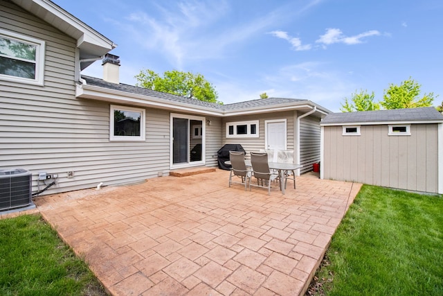 view of patio / terrace with an outbuilding, central air condition unit, and a shed