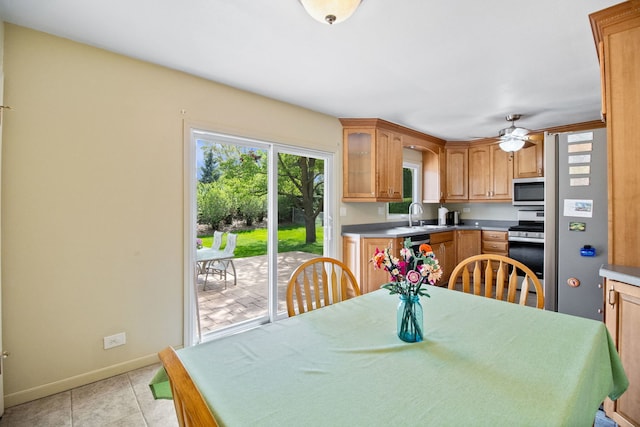 kitchen with stainless steel appliances, baseboards, ceiling fan, a sink, and light countertops