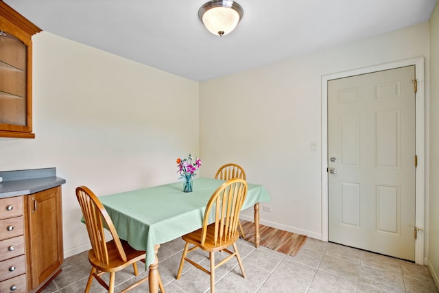 dining room featuring light tile patterned flooring and baseboards