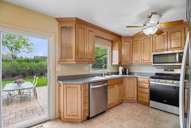 kitchen with appliances with stainless steel finishes, a sink, a ceiling fan, and light tile patterned floors