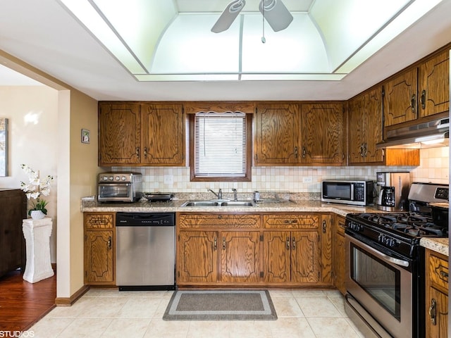 15720 Deerfield Ct Unit 2N, Orland Park, IL 60462 - kitchen featuring stainless steel appliances, under cabinet range hood, a sink, a ceiling fan, and backsplash