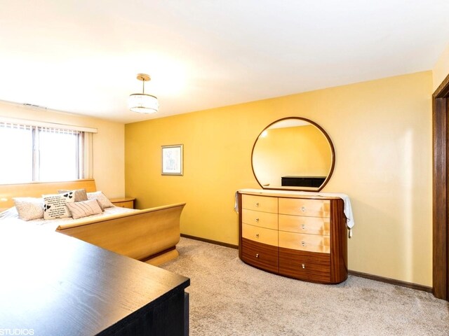bedroom with light carpet and baseboards