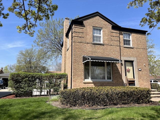 view of front of property with a chimney and brick siding
