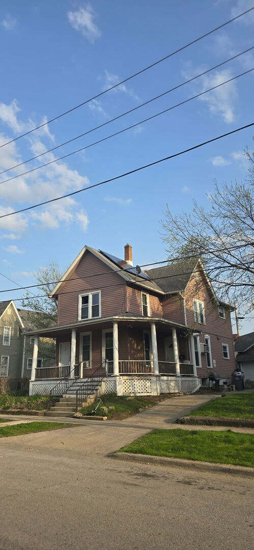 475 Laurel St, Elgin, IL 60120 - view of front facade with covered porch, a chimney, and roof mounted solar panels