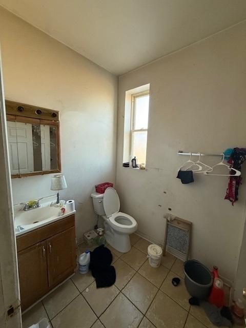 half bathroom with tile patterned floors, vanity, and toilet