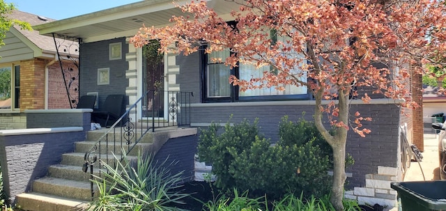 view of front of house featuring brick siding and covered porch