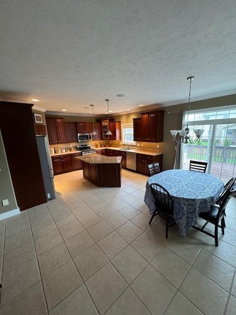 kitchen with a center island, light tile patterned flooring, appliances with stainless steel finishes, and a wealth of natural light