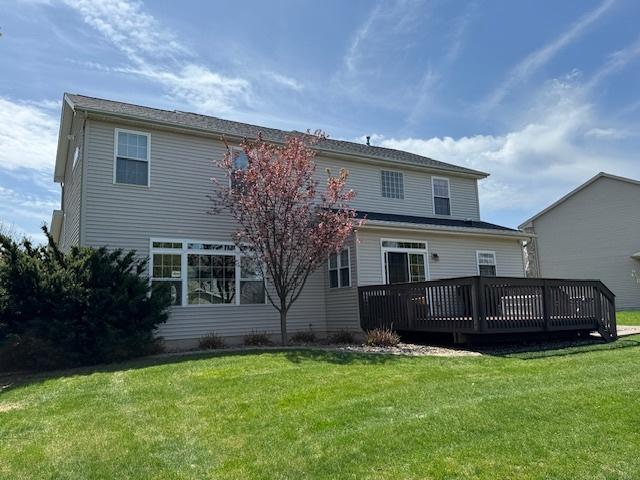 rear view of house with a wooden deck and a yard