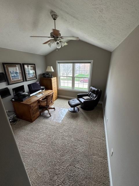 carpeted office featuring baseboards, a ceiling fan, a textured ceiling, and lofted ceiling
