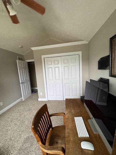 carpeted living room featuring crown molding, visible vents, ceiling fan, baseboards, and vaulted ceiling