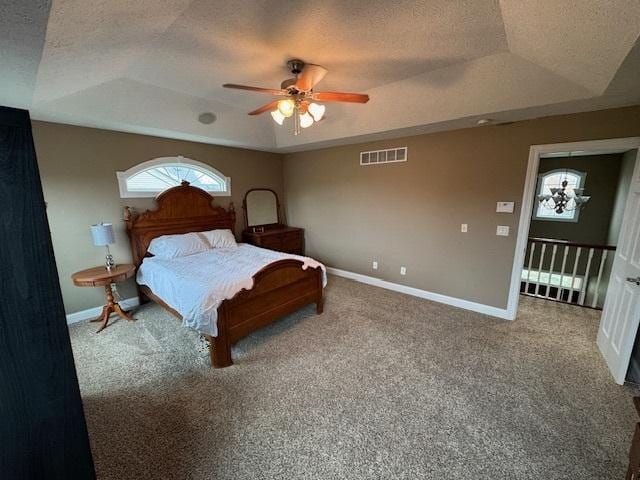 bedroom with carpet, visible vents, a tray ceiling, and baseboards