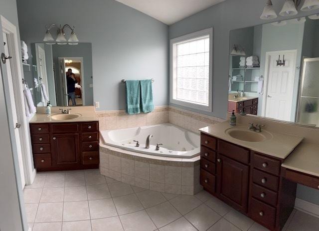 bathroom featuring tile patterned floors, a tub with jets, and a sink
