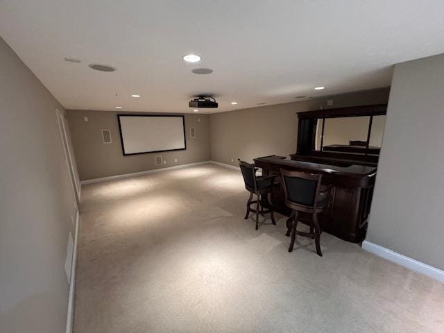 home theater room featuring baseboards, recessed lighting, and light carpet