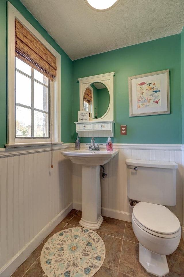 403 W 13th St, Sterling, IL 61081 - bathroom featuring tile patterned floors, toilet, and a wainscoted wall