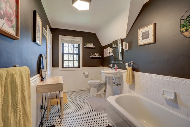 403 W 13th St, Sterling, IL 61081 - bathroom with lofted ceiling, a bathing tub, toilet, tile patterned floors, and wainscoting