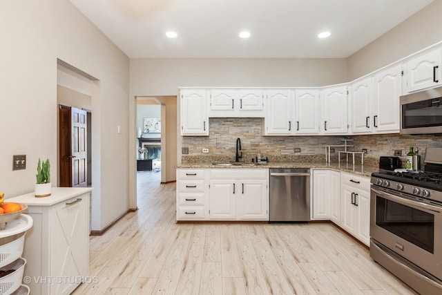 960 Heathrow Ln, Naperville, IL 60540 - kitchen featuring light stone countertops, decorative backsplash, stainless steel appliances, a sink, and white cabinetry