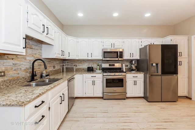 960 Heathrow Ln, Naperville, IL 60540 - kitchen with a sink, stainless steel appliances, light wood-style flooring, light stone counters, and white cabinetry