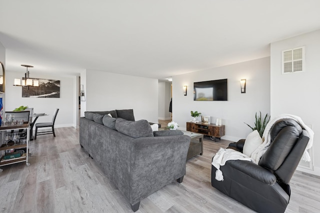 living area with visible vents, baseboards, and light wood-type flooring