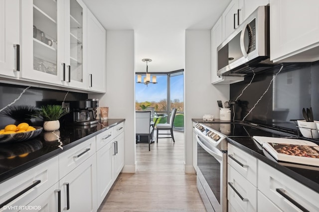 kitchen featuring dark countertops, stainless steel electric range oven, and expansive windows
