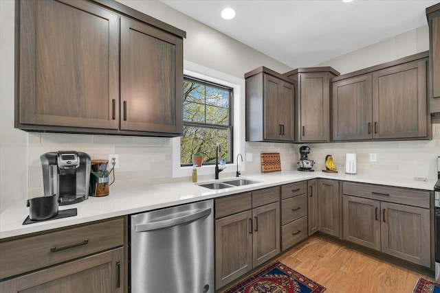 2102 Slade Ln E, Mahomet, IL 61853 - kitchen featuring stainless steel dishwasher, light countertops, a sink, light wood finished floors, and backsplash