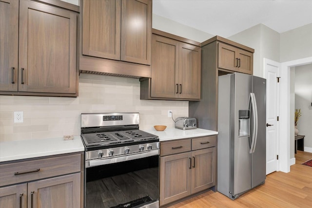 2102 Slade Ln E, Mahomet, IL 61853 - kitchen featuring decorative backsplash, light wood-style flooring, appliances with stainless steel finishes, and light countertops