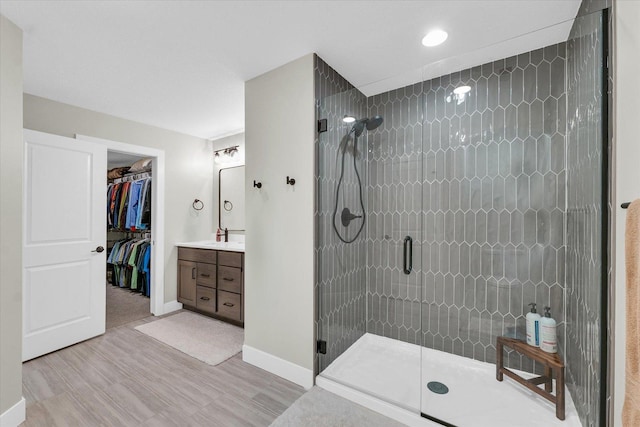 2102 Slade Ln E, Mahomet, IL 61853 - full bath with vanity, baseboards, a shower stall, wood finished floors, and a spacious closet
