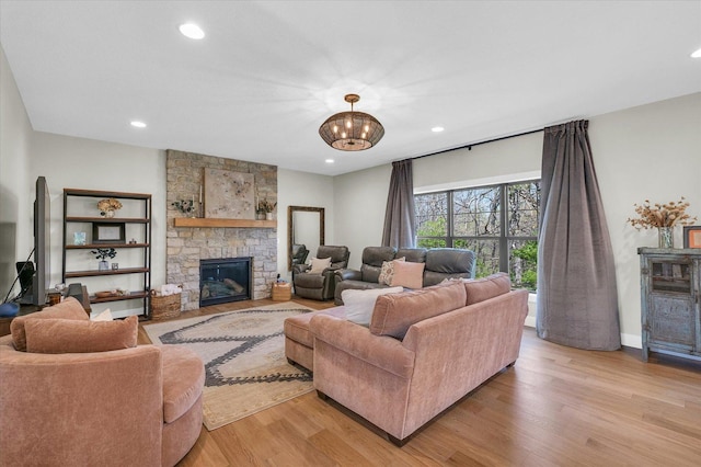 2102 Slade Ln E, Mahomet, IL 61853 - living room featuring light wood-type flooring, recessed lighting, a notable chandelier, and a stone fireplace
