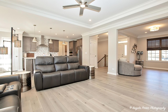 living room featuring recessed lighting, ornamental molding, ceiling fan, light wood finished floors, and baseboards