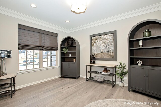 sitting room featuring light wood-type flooring, recessed lighting, ornamental molding, and baseboards