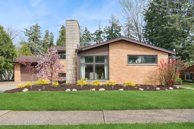 view of front facade featuring brick siding, concrete driveway, and a front yard