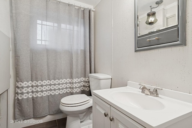 bathroom with toilet, a shower with shower curtain, and vanity