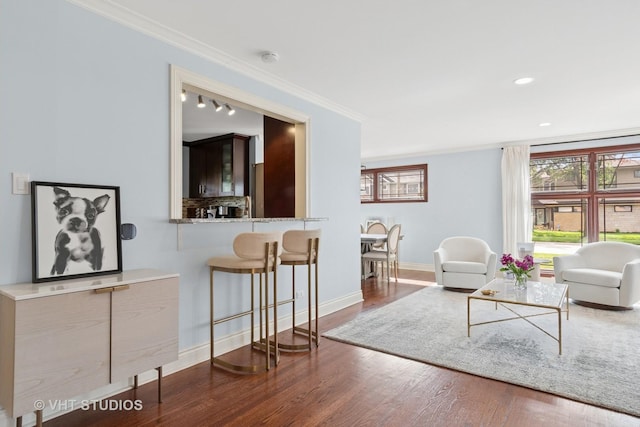 living room with ornamental molding, wood finished floors, baseboards, and recessed lighting