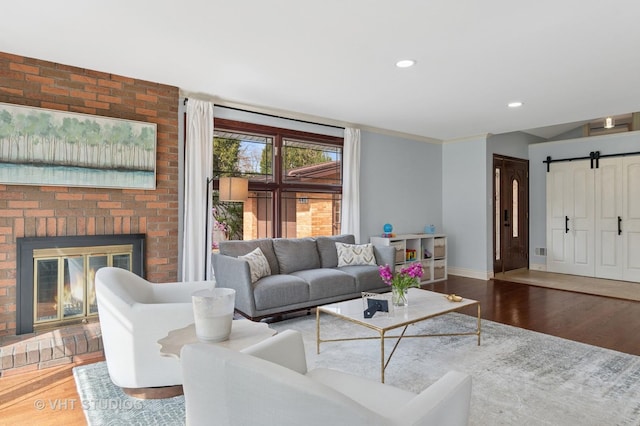 living room with wood finished floors, baseboards, a fireplace, and recessed lighting