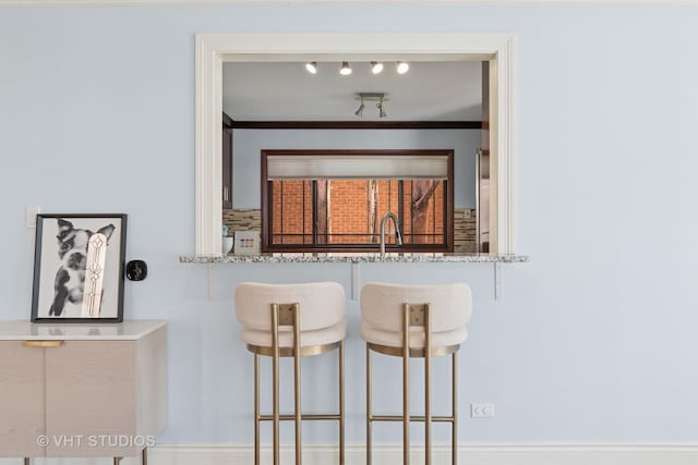 kitchen featuring ornamental molding and a breakfast bar area