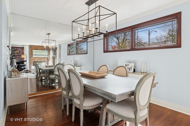 dining room with a chandelier, dark wood finished floors, and baseboards