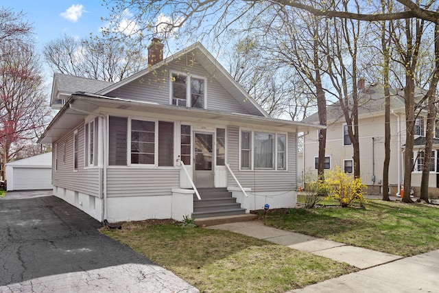 825 Saint John St, Elgin, IL 60120 - bungalow with a front lawn, a garage, a shingled roof, an outbuilding, and a chimney