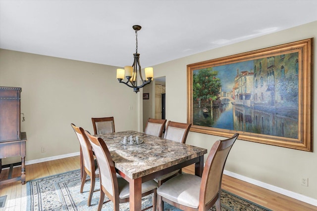 dining area with an inviting chandelier, baseboards, and wood finished floors