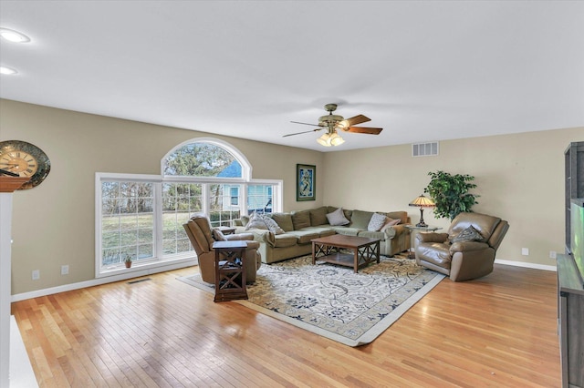 living area with visible vents, baseboards, ceiling fan, and hardwood / wood-style flooring