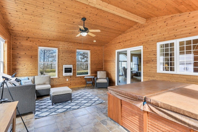 living area featuring ceiling fan, lofted ceiling with beams, wood walls, and a wealth of natural light