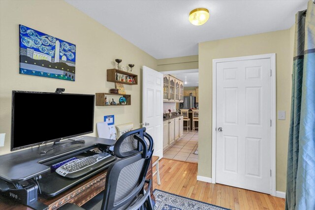 office area with light wood-style floors and baseboards