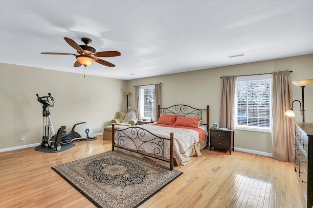 bedroom with a ceiling fan, baseboards, visible vents, and light wood-type flooring